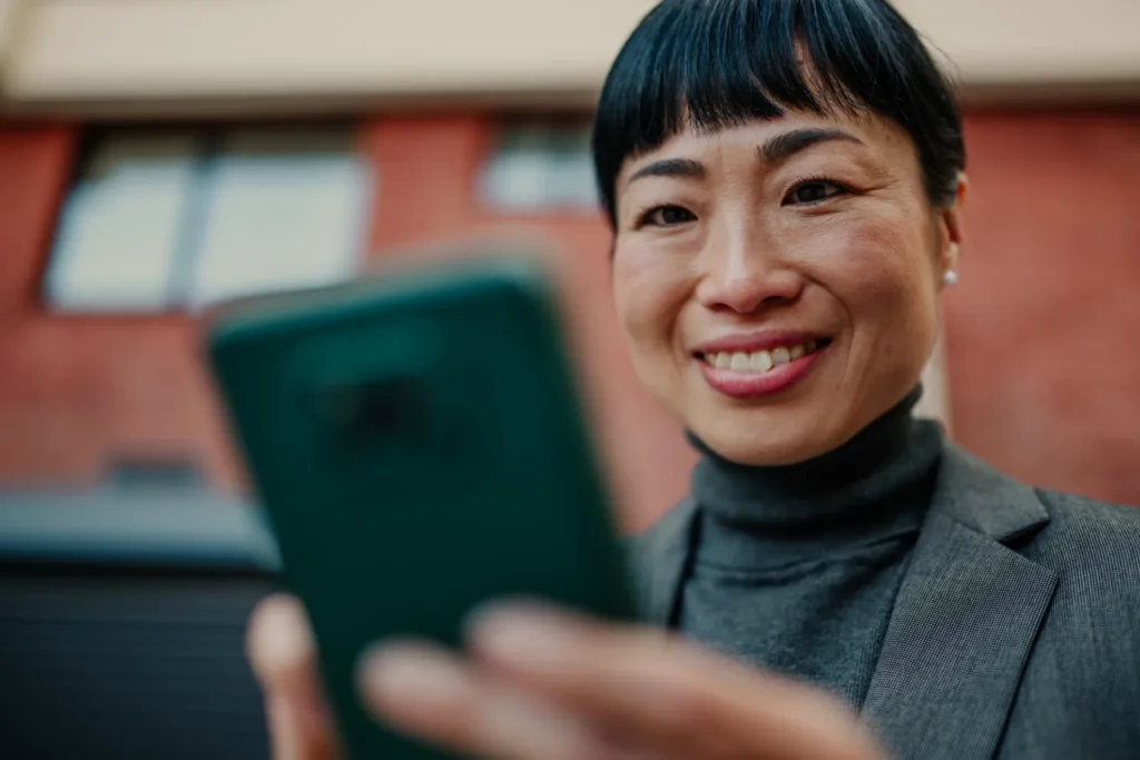 Asian woman looking at her mobile phone solution